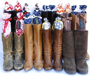 Several pairs of boots standing upright with decorative fabric boot inserts designed to keep boots organized and maintain their shape.