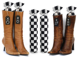 One Pair of 15-inch-tall fabric boot inserts covered in black and white checkered fabric, with black wooden tags reading "I Love You.” tied around the top of the insert Any message can be written on the black wooden tags. And two pairs of boots with the boot tree inserts inside them keeping them upright.
