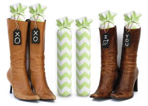 One Pair of 15-inch-tall fabric boot inserts covered in white fabric with green chevrons and with black wooden tags reading "I Love You.” tied around the top of the insert. Any message can be written on the black wooden tags. And two pairs of boots with the boot tree inserts inside them keeping them upright.