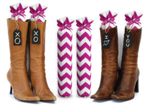 One Pair of 15-inch-tall fabric boot inserts covered in white fabric with pink chevrons and with black wooden tags reading "I Love You.” tied around the top of the insert. Any message can be written on the black wooden tags. And two pairs of boots with the boot tree inserts inside them keeping them upright.